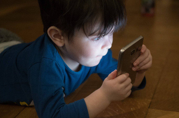 un niño/a mirando un móvil