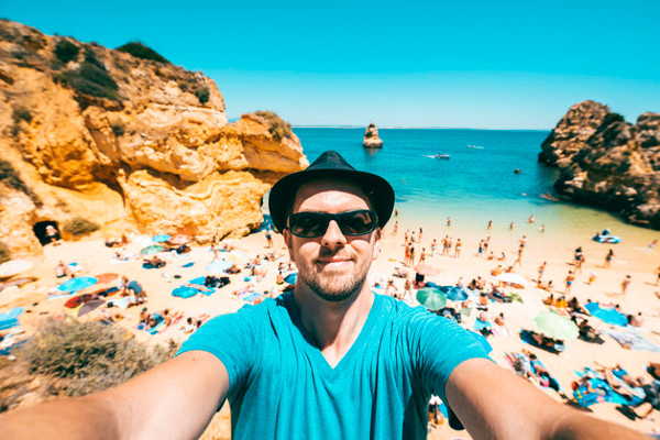 Un señor haciéndose un selfie en una playa